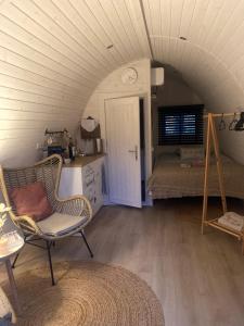 a room with a chair and a bed in a room at Ecolodge Almere with private outdoor terrace & beach in Almere