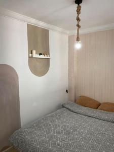 伊夫兰Cozy App in the Heart of Ifrane的卧室配有一张床,墙上设有架子