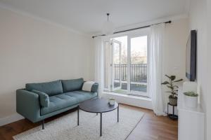 チェルムスフォードにあるModern 2 bed town house quiet street near stationのソファと窓のあるリビングルーム