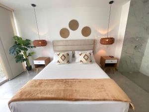a bedroom with a large bed with two tables and two lamps at Belmonte502-Apartaestudio en zona exclusiva con piscina in Armenia +18 photos