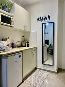 a kitchen with white cabinets and a mirror on the wall at כמו חדר במלון מרפסת חניה פרטית in Tel Aviv