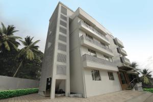 a large white building with palm trees in the background at Park Connect in Cochin