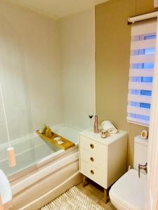 a bathroom with a tub and a toilet and a sink at Lakeside mini lodge in Saint Osyth +27 photos
