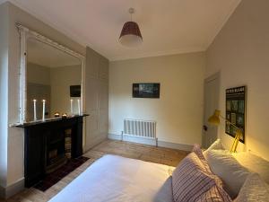 a living room with a bed and a fireplace at 2 bed luxe garden apartment in London