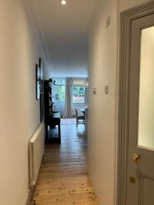 a hallway with a door and a table in a room at 2 bed luxe garden apartment in London