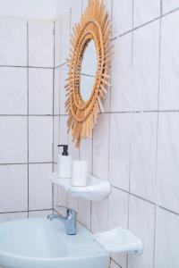 ein Badezimmer mit Spiegel und Waschbecken in der Unterkunft De Bali à Conaky *KIPE* in Conakry