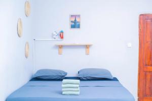 ein Schlafzimmer mit einem blauen Bett und einem Tisch darauf in der Unterkunft De Bali à Conaky *KIPE* in Conakry