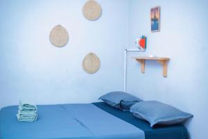 ein blaues Zimmer mit einem Bett und einem Tisch in der Unterkunft De Bali à Conaky *KIPE* in Conakry