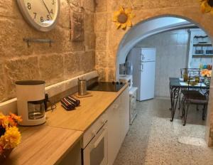 a kitchen with a counter and a clock on the wall at Sliema historic townhouse in Sliema