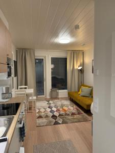 a kitchen and living room with a couch in a room at Studio Mukka, Ivalo Center in Inari