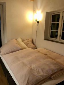 a bed in a room with a lamp and a window at Kleines modernes Haus in Borghamn in Borghamn