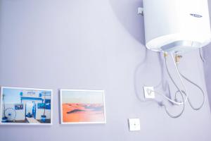 three pictures hanging on a wall with a light at De Tunis à Conakry KIPÉ in Conakry +13 photos