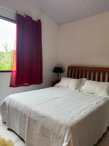 a bedroom with a white bed with a window at O refugio do beija-flor in Angra dos Reis +27 photos