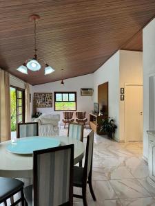 a dining room and living room with a table and chairs at O refugio do beija-flor in Angra dos Reis