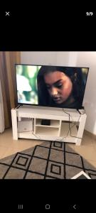 a flat screen tv sitting on a white entertainment center at Joli appartement a saly pres de barracuda in Saly Portudal