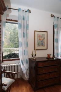 a bedroom with a dresser and a large window at casa margherita in Pieve di Teco