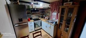 a kitchen with a stainless steel refrigerator and white cabinets at Zoe garden home in Spata