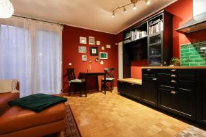 a living room with red walls and a desk with a couch at Ferienwohnung Altstadt in Erfurt