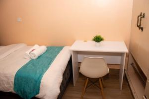 EmbuEmbu Air-bnb 1&2 Bedroom homestay的小房间设有一张床、一张桌子和一把椅子