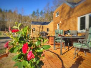 a wooden deck with a table and a desk at Ferien im Tiny House in Stuer