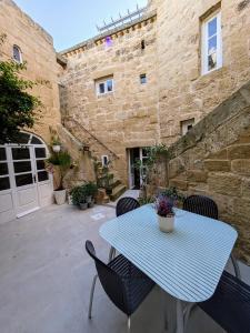 a blue table and chairs on a patio at Traditional Maltese House in centre of Town in Mosta
