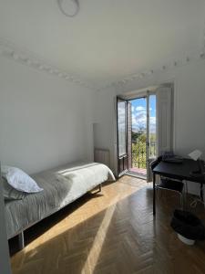 une chambre avec un lit, un bureau et une fenêtre dans l'établissement Creativity Quarters Habitación temporada en coliving para estudiantes, trabajadores y artistas, à Madrid
