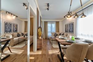 a dining room and living room with a table and chairs at Lenika Apartments in Zlatibor