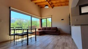 a living room with a table and chairs and a couch at Refugio Serrano in Merlo