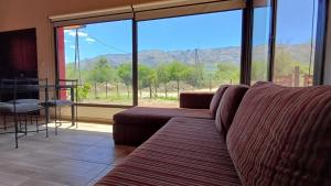 梅洛Refugio Serrano的带沙发和大窗户的客厅