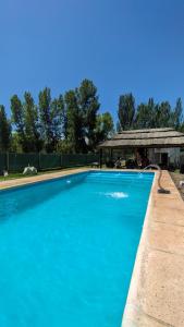 a large blue swimming pool with a gazebo at La Campigna, Neuquen in Plottier
