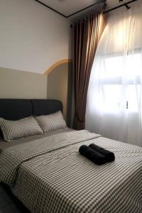 a bed with a black towel sitting on top of it at Residensi Mutiara, Kajang 2 - 3 Bedroom condo with Forest View in Kajang +10 photos