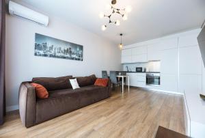 a living room with a couch and a kitchen at Nyvky Like Home - Файна Таун з басейном - Кв 398 in Kyiv