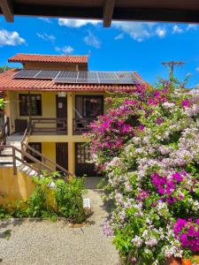 una casa con dei fiori davanti di 6 - Apartamento de 02 quartos com jacuzzi em Bombas a Bombinhas