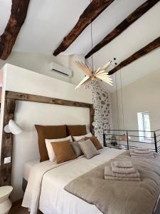 a bedroom with a large bed and a chandelier at La Clède du PontNeuf in Valleraugue