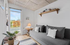a living room with a gray couch and a window at 3 Bedroom Nice Home In Roslev in Roslev +9 photos