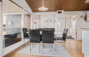 a dining room with a table and black chairs at 3 Bedroom Nice Home In Roslev in Roslev