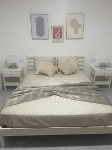 a bedroom with a bed with two end tables at Felicidade apartamento Palmarejo Grande in Praia