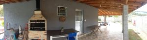 a kitchen in a house with a counter and a fireplace at Casa de Campo Chácara Cantinho dos Sonhos in Extrema