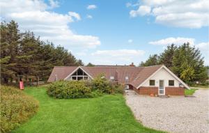 una casa con un vialetto di ghiaia davanti di Beautiful Home In Ringkøbing With Sauna a Klegod