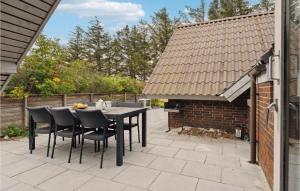 un patio con tavolo e sedie neri di Beautiful Home In Ringkøbing With Sauna a Klegod Altre 12 foto