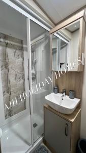 ein Badezimmer mit einem weißen Waschbecken und einer Dusche in der Unterkunft AJH Holiday Homes, Ty Mawr- Parkdeans Resort in Kinmel Bay + 9 Fotos