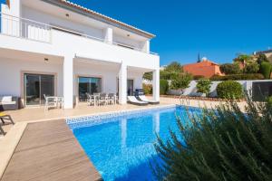 Villa Ofelia 46 by Destination Algarve في Santo Amaro: فيلا مع مسبح ومنزل