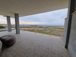a large patio with a view of the ocean at Dada Apartment in Fiumicino