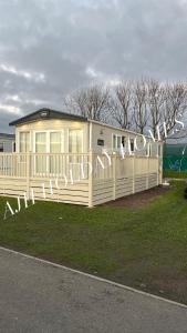 ein Mobilheim mit einem Zaun und einem Schild in der Unterkunft AJH Holiday Homes, Ty Mawr- Parkdeans Resort in Kinmel Bay