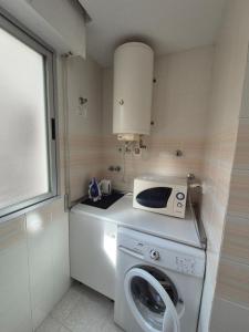 a kitchen with a washing machine and a microwave at Santa Pola Salamanca 10 apartamento, garaje subterráneo, fibra óptica, lavavajillas, aire acondicionado, gran terraza, Grand Playa 450m in Santa Pola