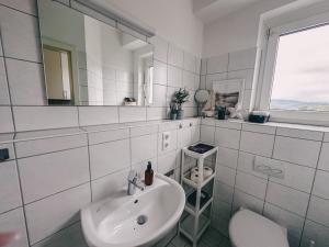 a white bathroom with a sink and a mirror at Zeit Raum Apartment Bayreuth in Bayreuth +9 photos