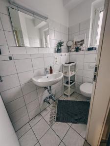 a white bathroom with a sink and a toilet at Zeit Raum Apartment Bayreuth in Bayreuth
