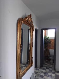 a gold mirror on a wall in a bathroom at Villa lumineuse proche plage in Wissant