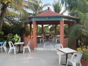 a gazebo with white chairs and tables and chairs at RESIDENCE BELIER KEUR MOUSSA in Mbirdiamm