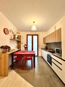 a kitchen with a red table and red chairs at Ca' Massima, il cuore a Monza in Lissone